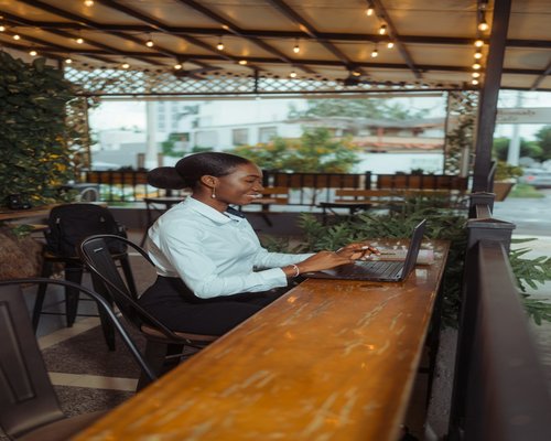 Woman adjusting her laptop angle at a cafe table