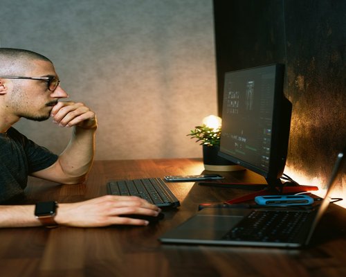 Person looking away from computer towards a window