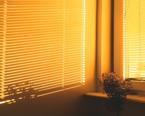 Sunlight streaming through window blinds into a calm room